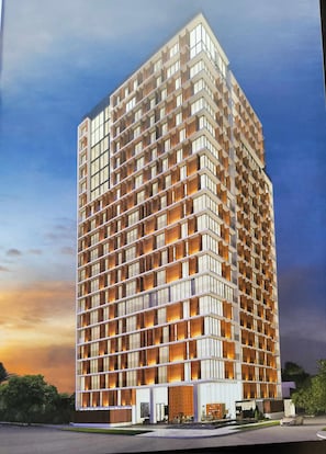 Un edificio moderno de gran altura con una fachada de balcones, ventanas amplias y techo plano.