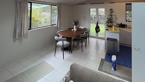 Ein modernes Wohnzimmer mit Esstisch, Sofa und Küchenbereich inklusive einer kleinen Kochinsel.