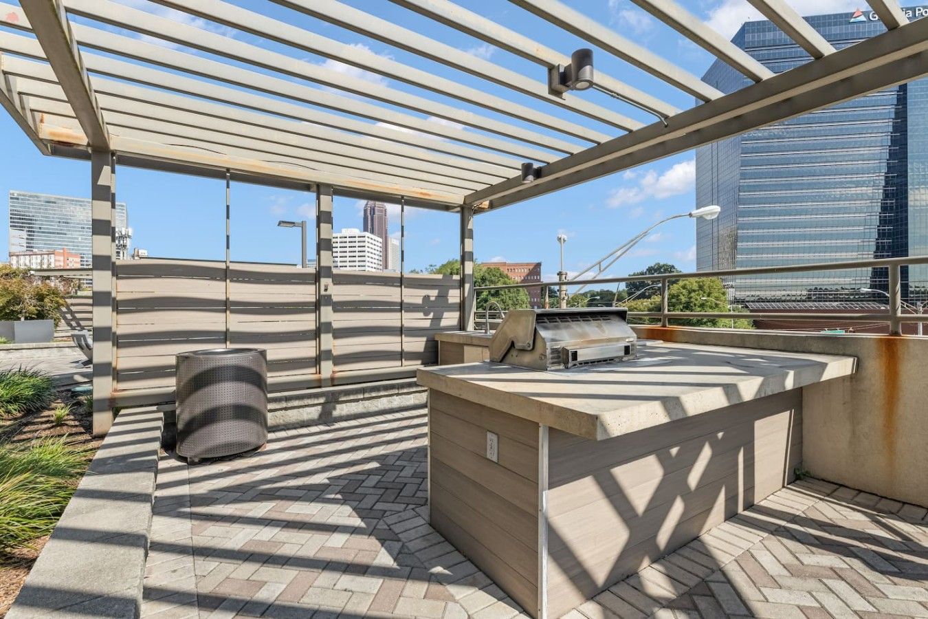 Un patio exterior con una parrilla, zona de estar y vistas de la ciudad.
