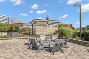 An outdoor patio with a pergola, seating area, and a view of the city skyline. - Stylish King Suite • Walk to Downtown (Atlanta)