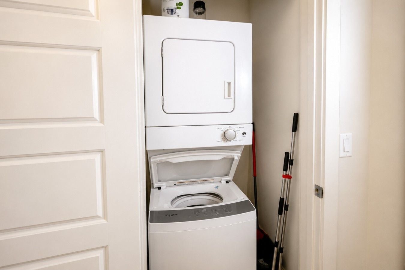 A laundry room with stacked appliances, including a dryer and a washing machine.