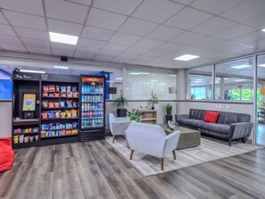 A modern waiting area with a vending machine, seating, and a view of the outdoors. - King Studio -waterfront views from private balcony with boat dock. (Sarasota)