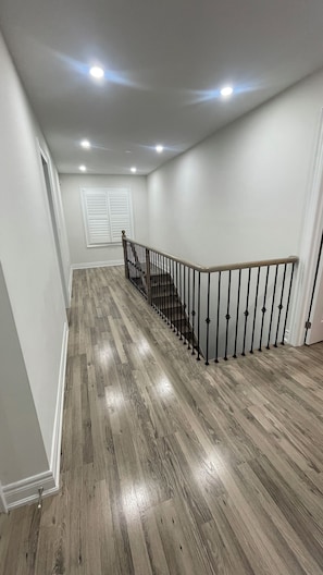 A staircase with a wooden finish and black balusters leading to a landing. - Spacious Private 4-Bedroom Detached Home Large family/living rooms & 2.5washroom (Pickering)