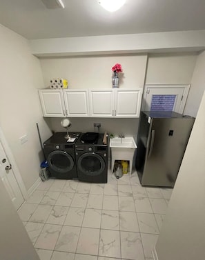 A compact kitchen with a washing machine, a refrigerator, and a sink. - Spacious Private 4-Bedroom Detached Home Large family/living rooms & 2.5washroom (Pickering)