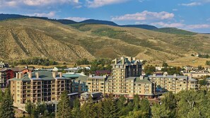 A hotel complex with multiple buildings, surrounded by forested hills.