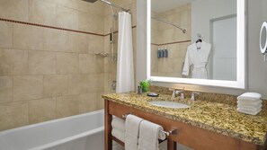 A bathroom with a bathtub, a sink, a mirror, and a shower.