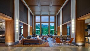 A spacious lobby with a large window offering a mountain view, a seating area with tables and chairs, and a bar area. - Luxury Studio Suites in Westin Riverfront Villa in Avon, CO -Minimum 3 nights (Avon)