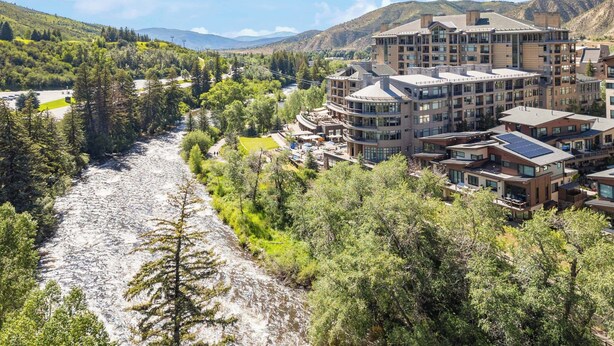 A modern hotel complex with multiple buildings, a river running through the property, and a mountainous backdrop. - Luxury Studio Suites in Westin Riverfront Villa in Avon, CO -Minimum 3 nights (Avon)