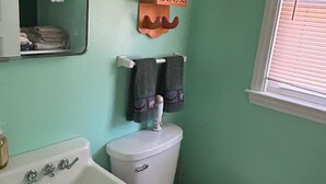 Ein Badezimmer mit Waschbecken, Toilette und Handtuchhalter.