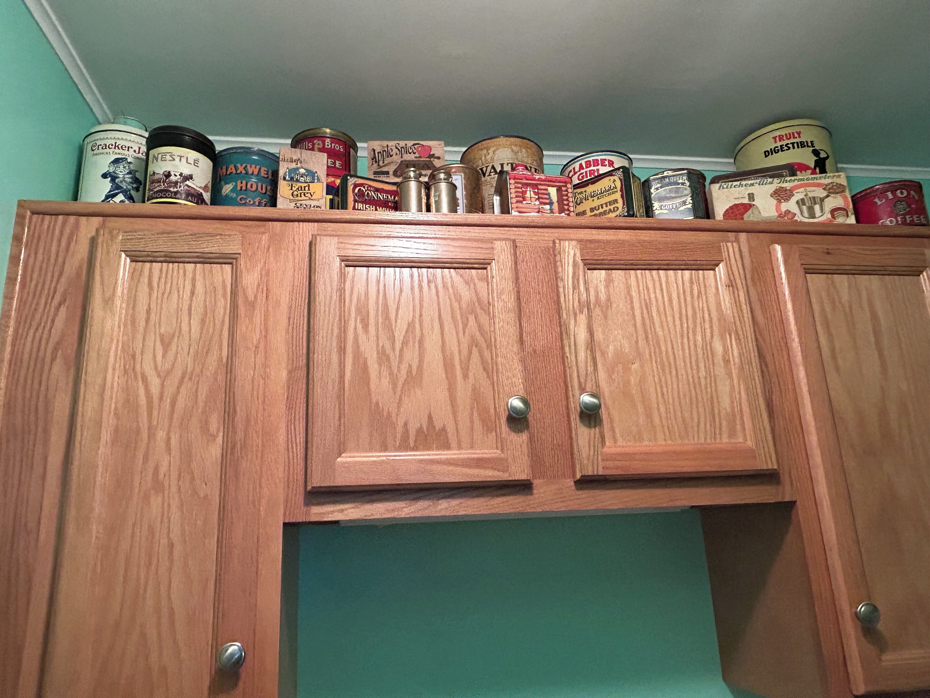 A wooden cabinet with multiple vintage food canisters on top.