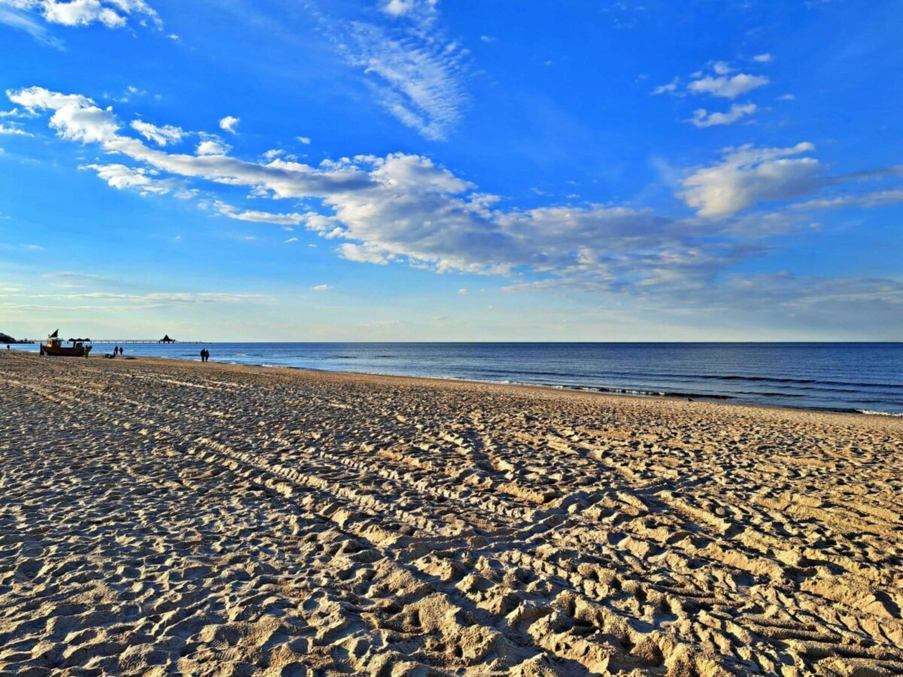 Una playa con cielo despejado y mar tranquilo.