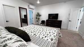 A bedroom with a bed, dresser, television, and a potted plant. - Modern Bremerton Escape Near Ferry & Seattle (Bremerton)