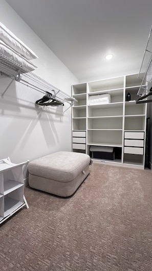 A bedroom with a bed, a bedside table, a wardrobe, and a hanging shoe rack. - Modern Bremerton Escape Near Ferry & Seattle (Bremerton)