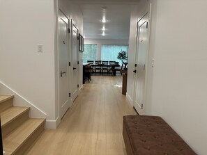 A hallway with a staircase, a dining area with a table and chairs, and a bench. - Modern Bremerton Escape Near Ferry & Seattle (Bremerton)