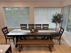 A dining area with a wooden table, six chairs, a bench, and a potted plant. - Modern Bremerton Escape Near Ferry & Seattle (Bremerton)