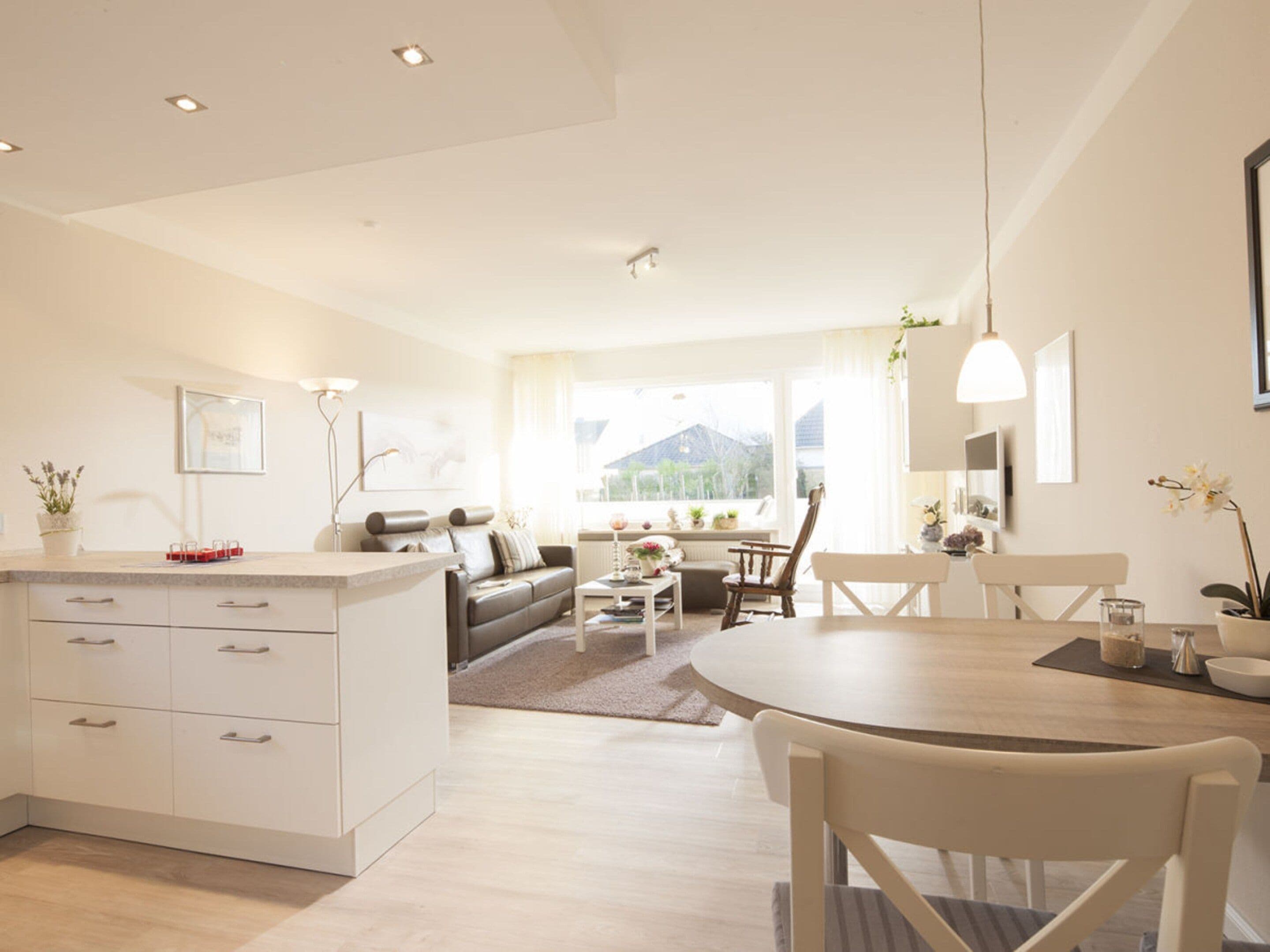 A modern living space with a kitchen, dining area, and seating.