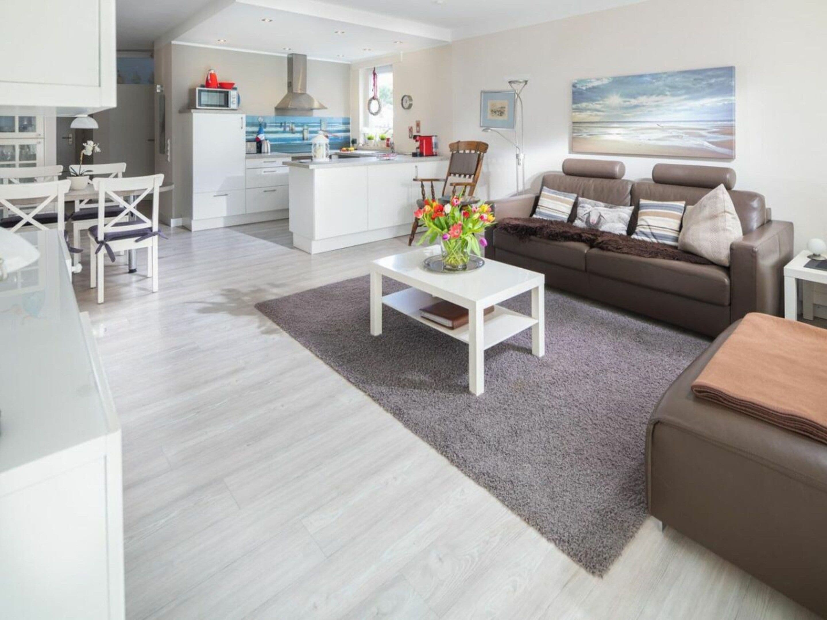 A modern living space with a kitchen, dining area, and a sofa set.