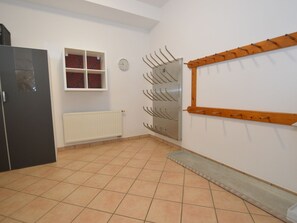 Une pièce avec un radiateur, une horloge, une porte et un étendoir fixé au mur.