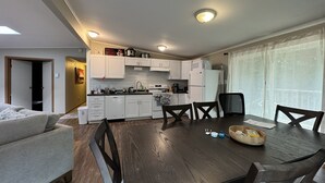 Un espacio habitable compacto con comedor, kitchenette y sofá.