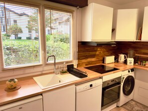 A modern kitchen with a dishwasher, oven, and a built-in washing machine. - Penon · 2 ch · Plage à pied, vélo, calme & repos (Seignosse)