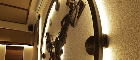 A wall-mounted clock with a circular frame and illuminated numbers.