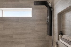 A modern bathroom with a shower, a window, and a towel rack. - Biophilic Oasis Knox Henderson (Dallas)
