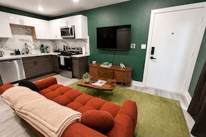 A modern kitchen with white cabinets, a microwave, and a stove. - Biophilic Oasis Knox Henderson (Dallas)