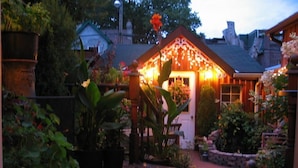 A well-lit garden area with a gazebo, potted plants, and a patterned rug. - The Willow House Toronto (Toronto)