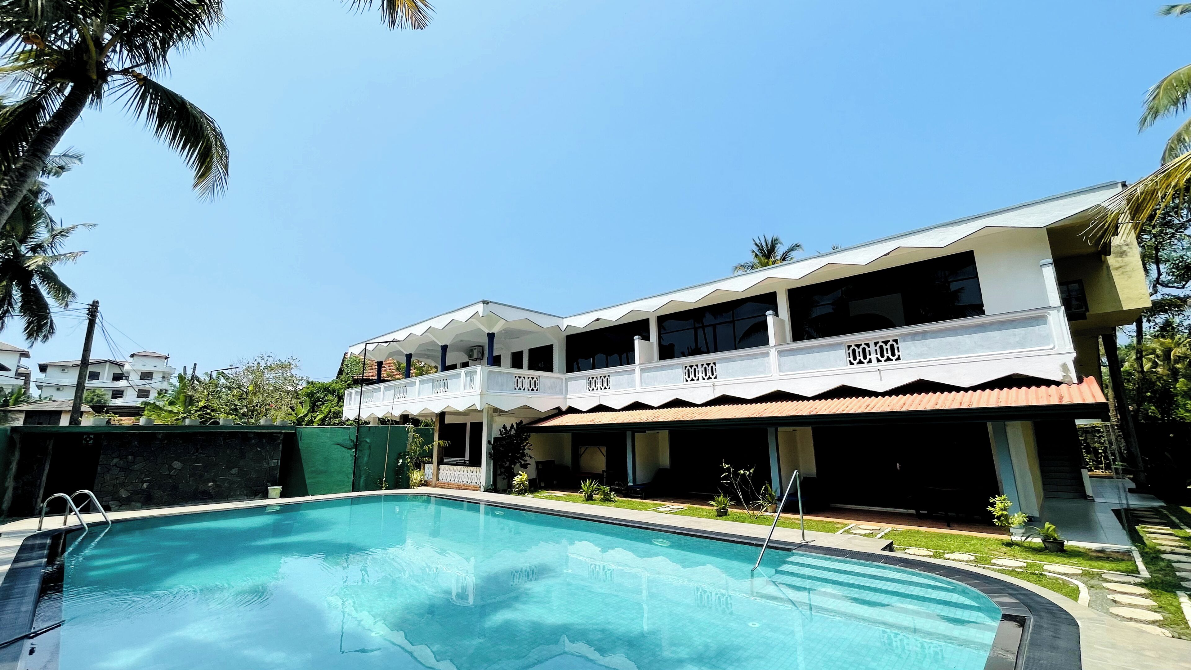 A two-story building with a swimming pool in front.