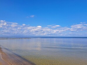 A calm beach with clear water, a wooden pier, and a clear sky. - Villa Bella, First row With sea View (Heringsdorf)