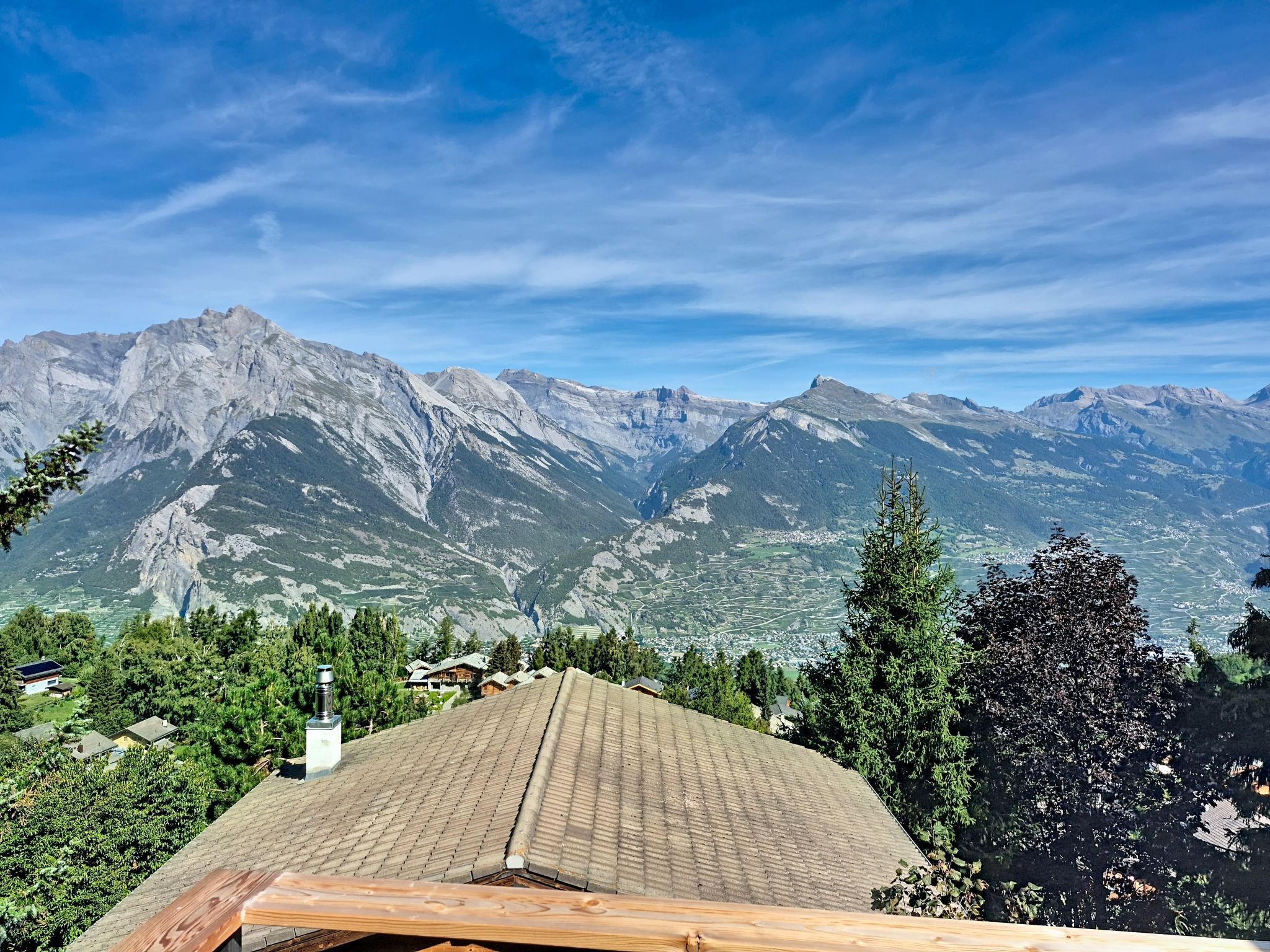 A mountain view with a wooden deck and a chimney.