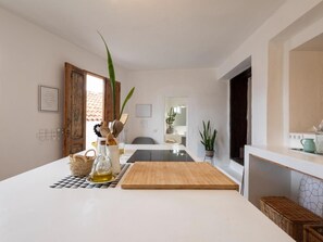 A kitchen with a wooden countertop, a cutting board, a bottle of oil, and a potted plant. - Finca Santa Catalina · 3 casitas · Private plunge pool (La Guancha)