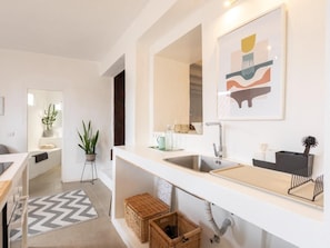 Ein modernes Badezimmer mit Waschbecken, Spiegel und einem gerahmten abstrakten Kunstwerk darüber.