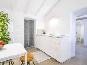 A modern kitchen with white cabinetry, a countertop, a sink, and a potted plant. - Casita Romántica · Stone walls · Shared plunge pool (La Guancha)