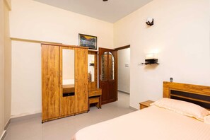 Ein Schlafzimmer mit einem Bett, einem Holzschrank und einem Spiegel.