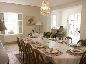 A dining room with a long table set for a meal, surrounded by chairs. - Private Pool Stay in Heart of Luberon (Lagnes)