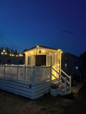 A small, single-story building with a porch and a staircase leading to the entrance. - Clear Water Holidays (Northampton)
