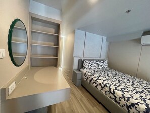 A bedroom with a bed, built-in shelving, a mirror, and a bedside table. - Duplex 1-bedroom Apartment in Thonglor, Bangkok (Bangkok)
