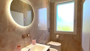 A modern bathroom with a vanity, a toilet, and a large mirror. - Vrbo Property (Castel Bolognese)