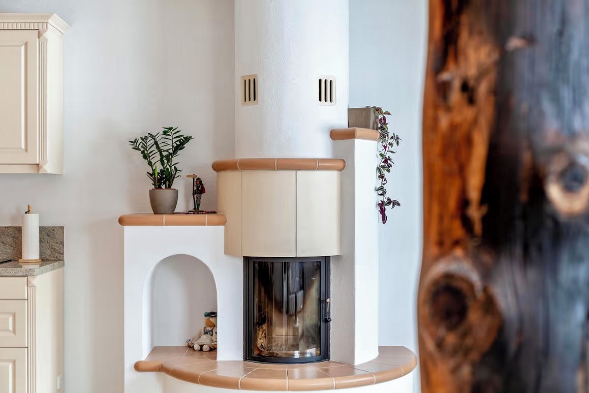 Una cocina moderna con chimenea empotrada, armarios de madera y una planta en maceta.