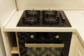 A kitchen with a four-burner gas stove and a built-in oven. - Premium House, 3BR, Renovated, Best Loc Kadıköy (Kadıköy)