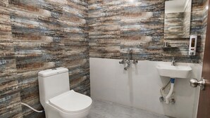 Ein Badezimmer mit Toilette, Waschbecken und Duschbereich.