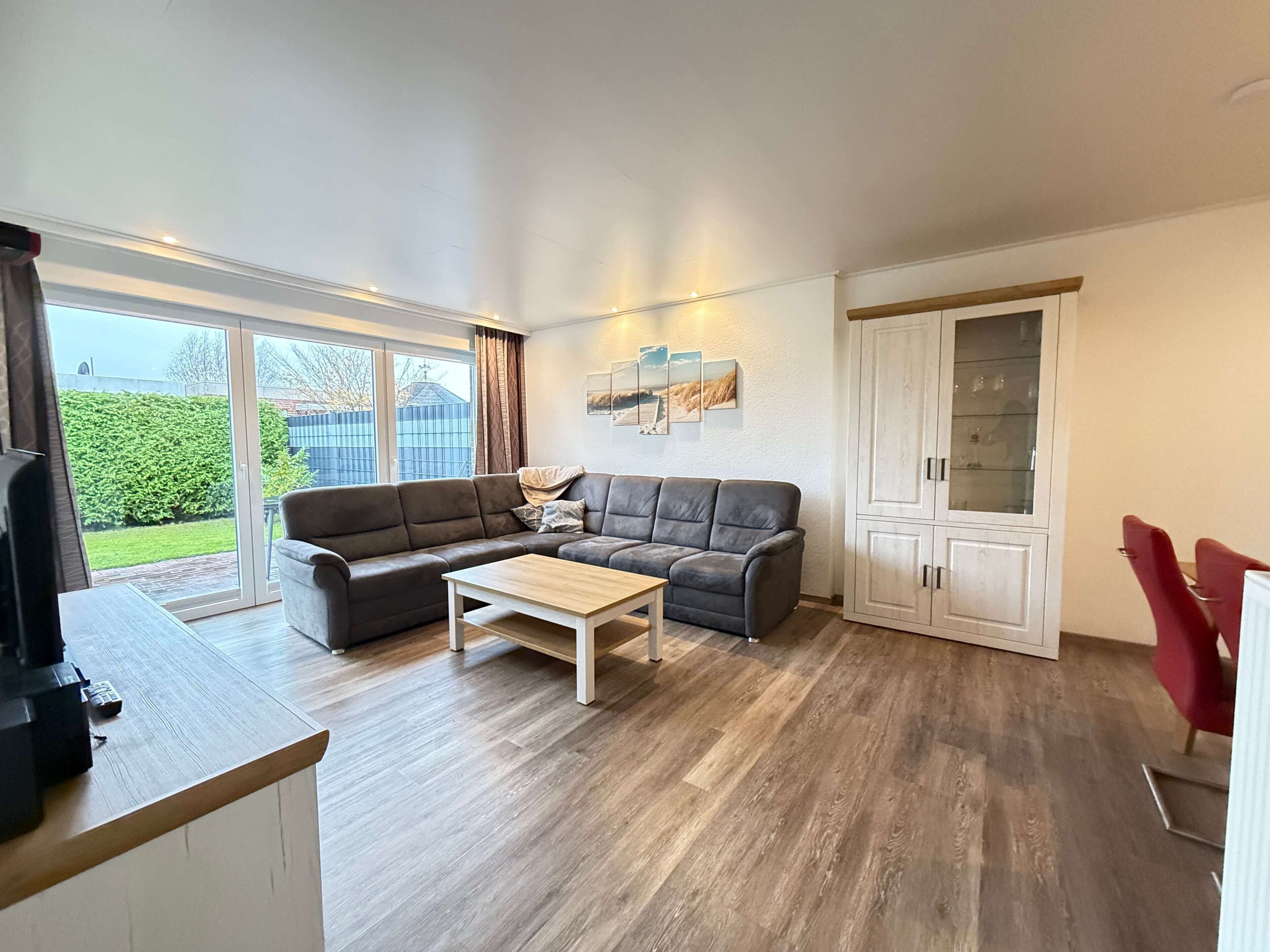 A living room with a sectional sofa, a coffee table, and a cabinet.