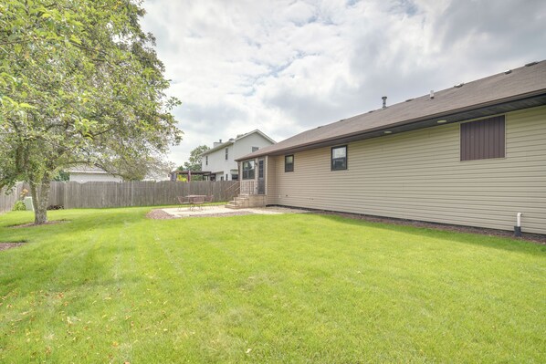 A residential property with a fenced backyard, a patio area, and a single-story building with a gabled roof. - Peaceful Joliet Retreat Near Dtwn & Route 66 (Joliet)