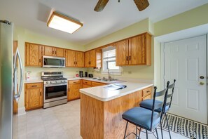 A kitchen with wooden cabinets, a stainless steel refrigerator, an LG microwave, a stove, and a sink. - Peaceful Joliet Retreat Near Dtwn & Route 66 (Joliet)