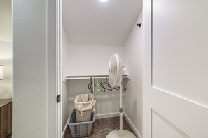 A corner room with a white wall, a standing fan, a laundry basket, and a door. - Mtn-Views! Flagstaff Extended Escape Near Hiking (Flagstaff)