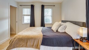 Un dormitorio con cama, mesita de noche, lámpara y ventilador de techo.