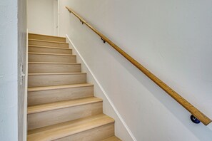 Una escalera de madera con barandilla y un objeto azul en la parte inferior.