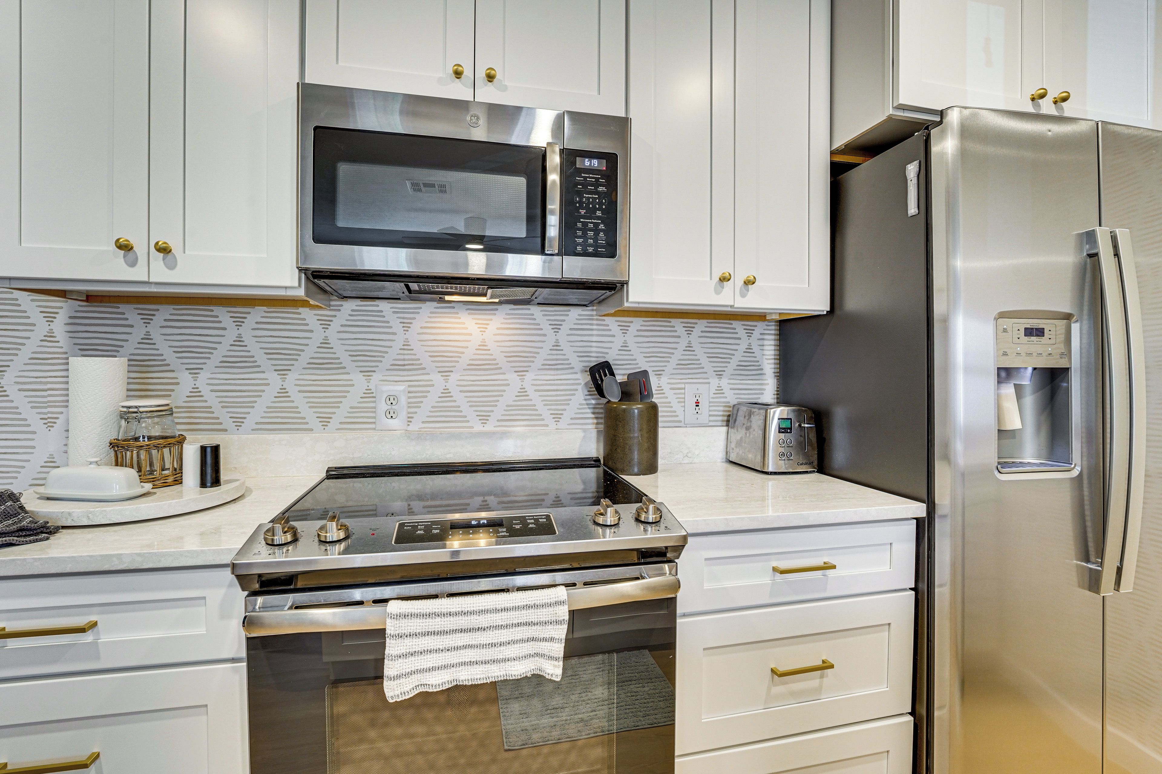 A modern kitchen with stainless steel appliances, including a microwave, oven, and refrigerator.