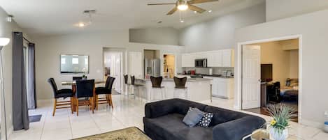 A spacious living area with a dark sofa, a glass coffee table, and a patterned rug.